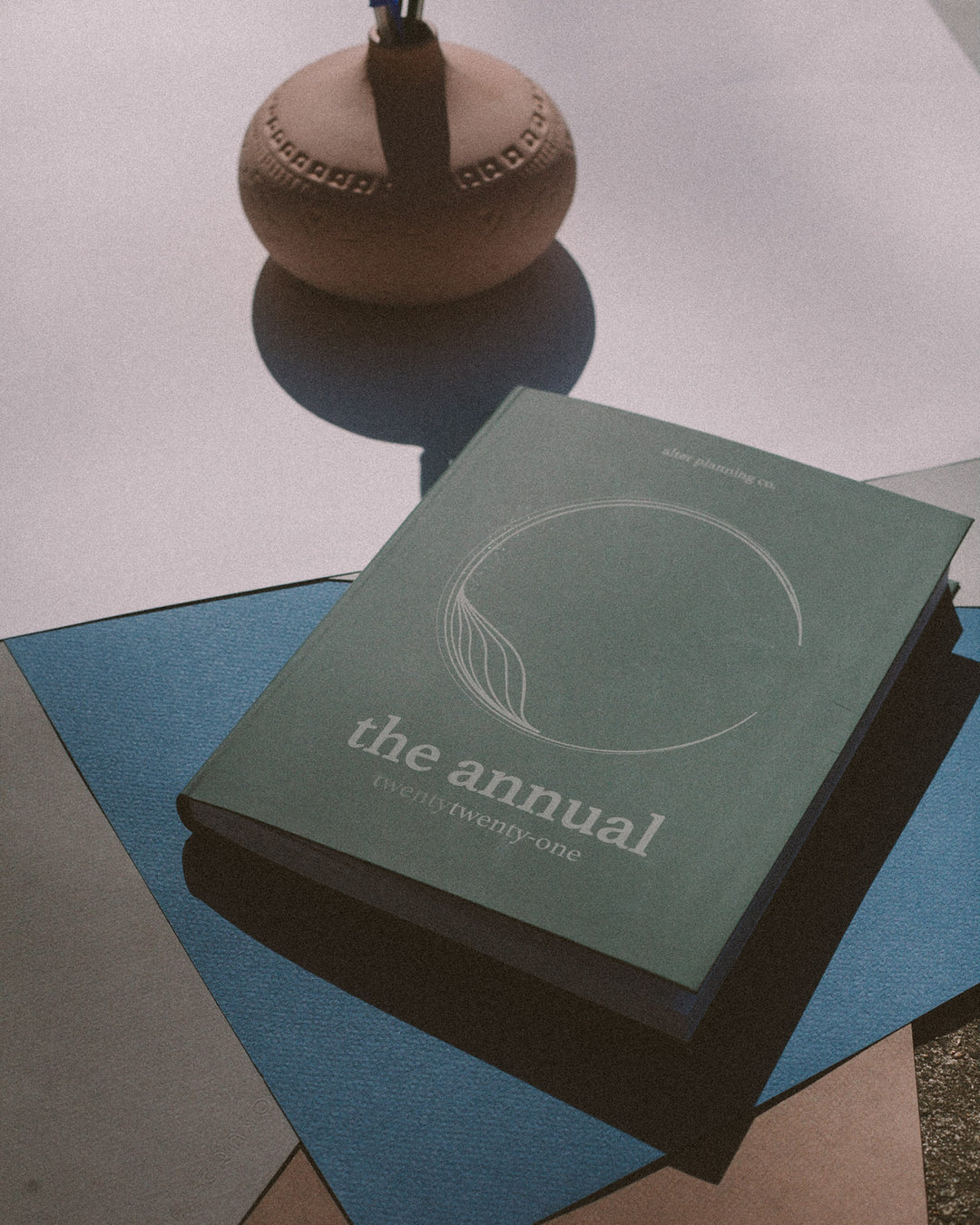 image of alter planning co. product "The Annual" in green, on a blue and white background. 