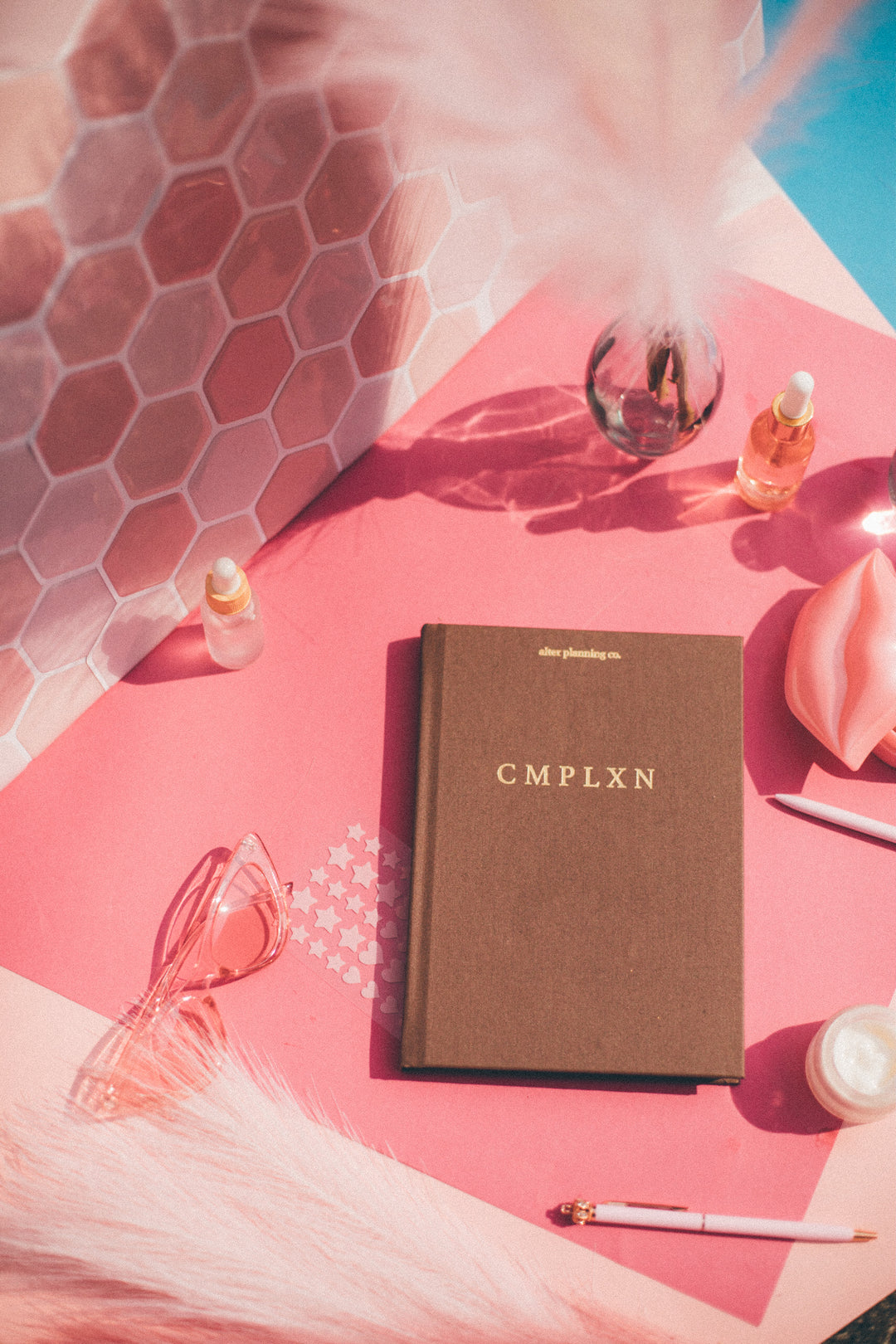 Graphic that reads "Announcing CMPLXN" (alter planning co's newest product; a skin care journal) Graphic also features illustrations of women in face masks and skin care products.